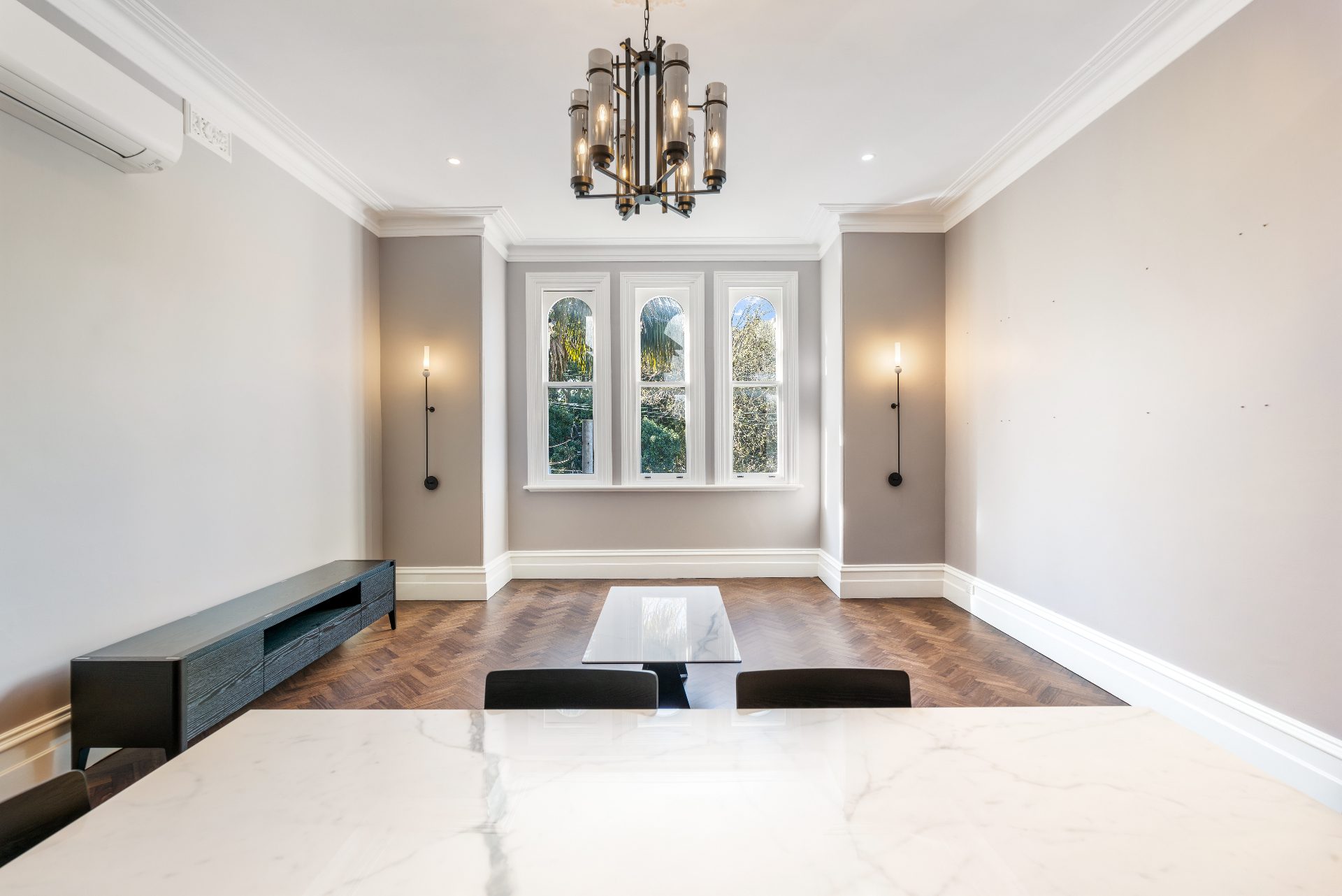 Period living room with arched windows and herringbone floors